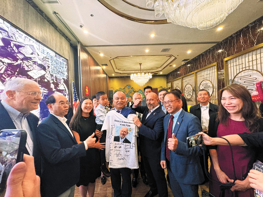 劉龍珠（前排左4）代表華人社區贈送簽名T恤。記者陸新攝