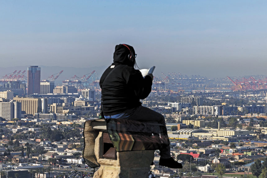 一名女子坐在信號山山頂公園讀書，該公園俯瞰長堤港和洛杉磯港。美聯社