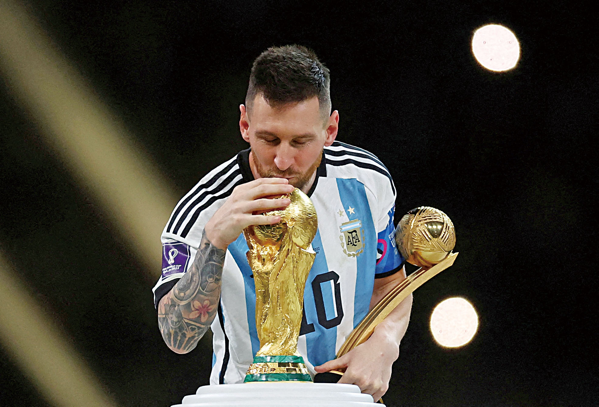 2022年12月18日，美斯率阿根廷國家隊在贏得世界盃冠軍後慶祝金球獎，親吻世界盃獎盃，登上職業生涯巔峰。路透社資料圖片