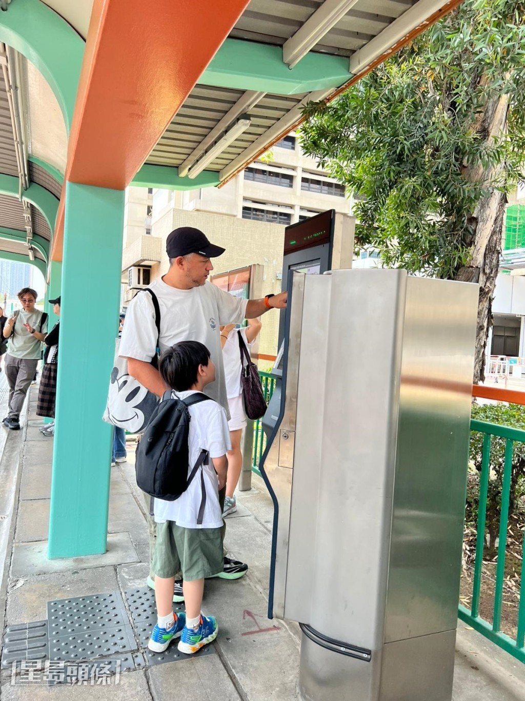 Steven在月台教7歲兒子張天寶認識輕鐵站名。