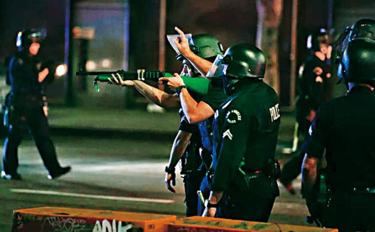 2020年，道奇隊贏得世界大賽冠軍後，一名洛市警察在市中心用非致命性武器瞄準人群。洛杉磯時報