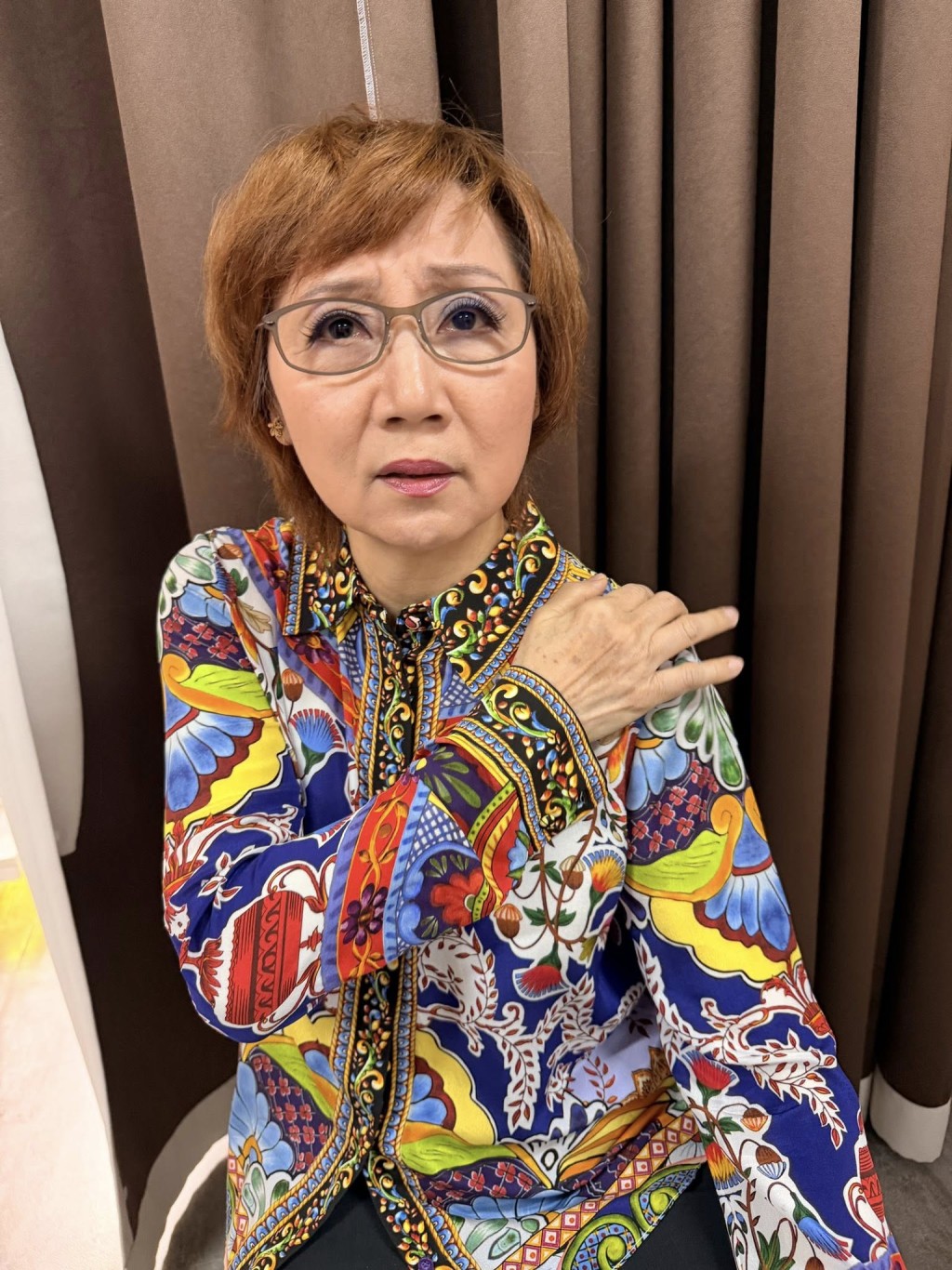 4月15日，張德蘭以手按着肩膀，神情略顯痛楚。