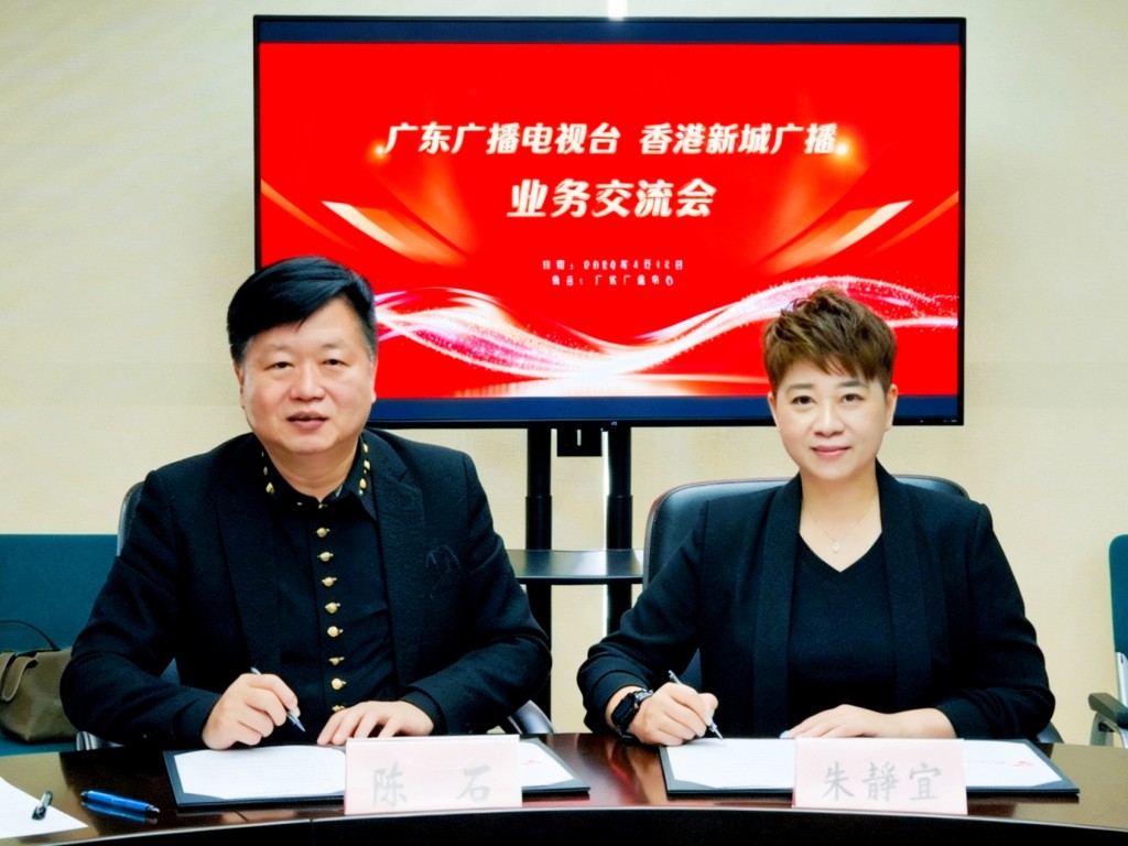 廣東音樂之聲副總監陳石（左）與新城廣播總經理朱靜宜，在雙方領導見證下簽署合作備忘錄。