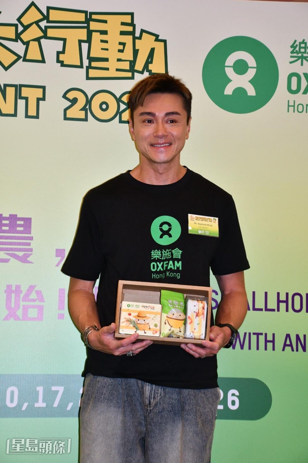 發哥(周潤發)請他呼籲大家購買樂施米,協助山區農民學習新科技農耕,發展自給自足的經濟。