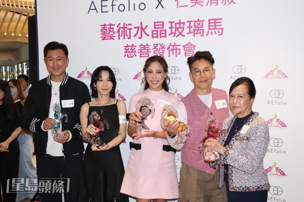 五人一同手持一座設計精緻的玻璃馬紀念品。