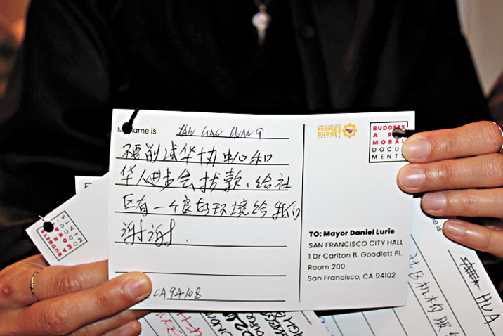 民眾以中文書寫明信片,向市長羅偉表達反對削減社區服務的訴求。記者陳程威攝