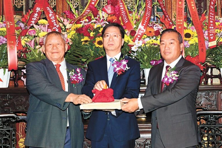 中領館總領事張建敏（中）主持監交，新任總董朱明沾（左）從滿任總董黃建成（右）手中接過印信，履新上任。馬紅兵攝