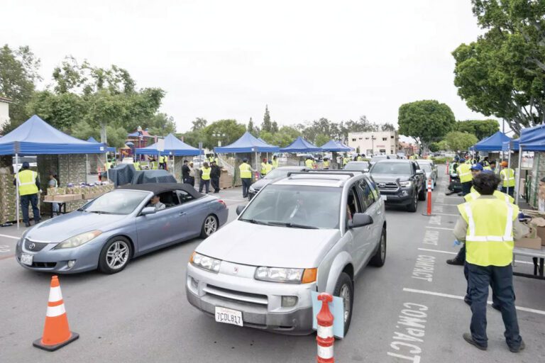在鮑德溫公園舉行的免下車食品發放活動中，居民排長隊領取食品。洛杉磯縣政府