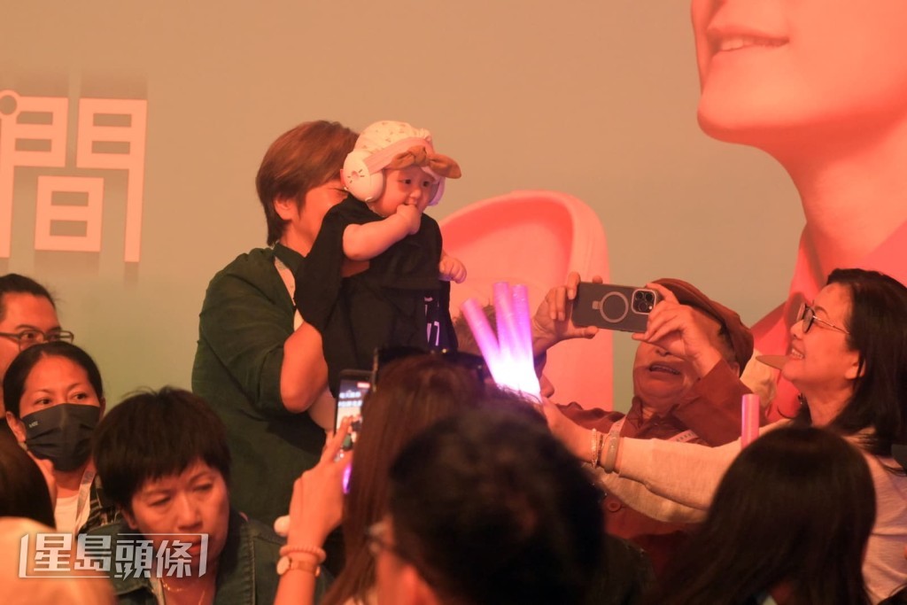 小方媽媽興奮地站起身抱起孫女Isla。