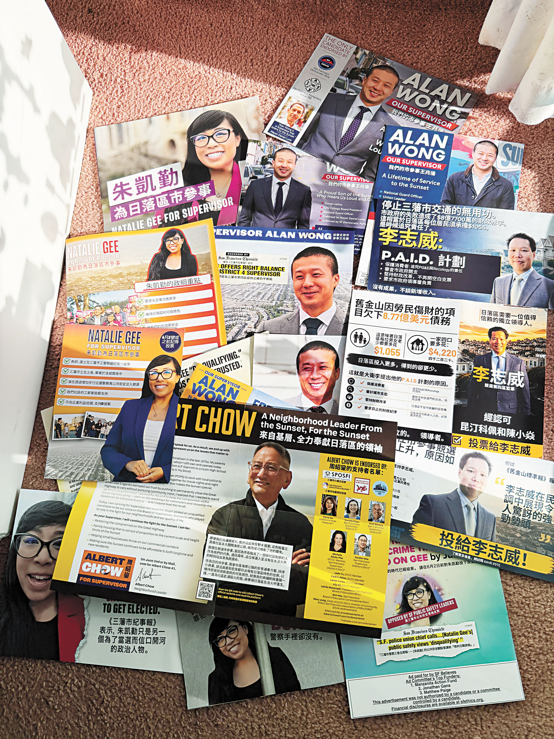 日落區居民李女士向本報展示近日家中收到的大量第4區市參事候選人宣傳單張。受訪者提供