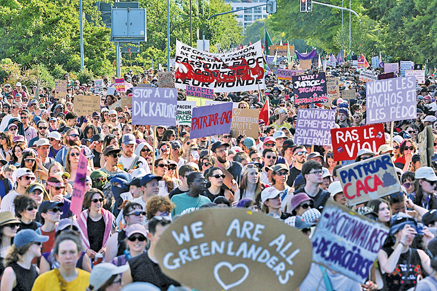 在瑞士日內瓦,示威民眾舉著標語牌和標語牌抗議G7峰會。路透社