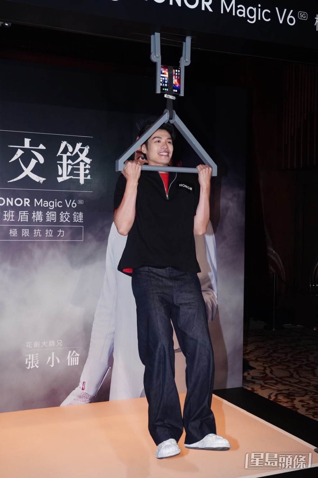 張小倫在活動中以手機掛上繩索做引體上升。