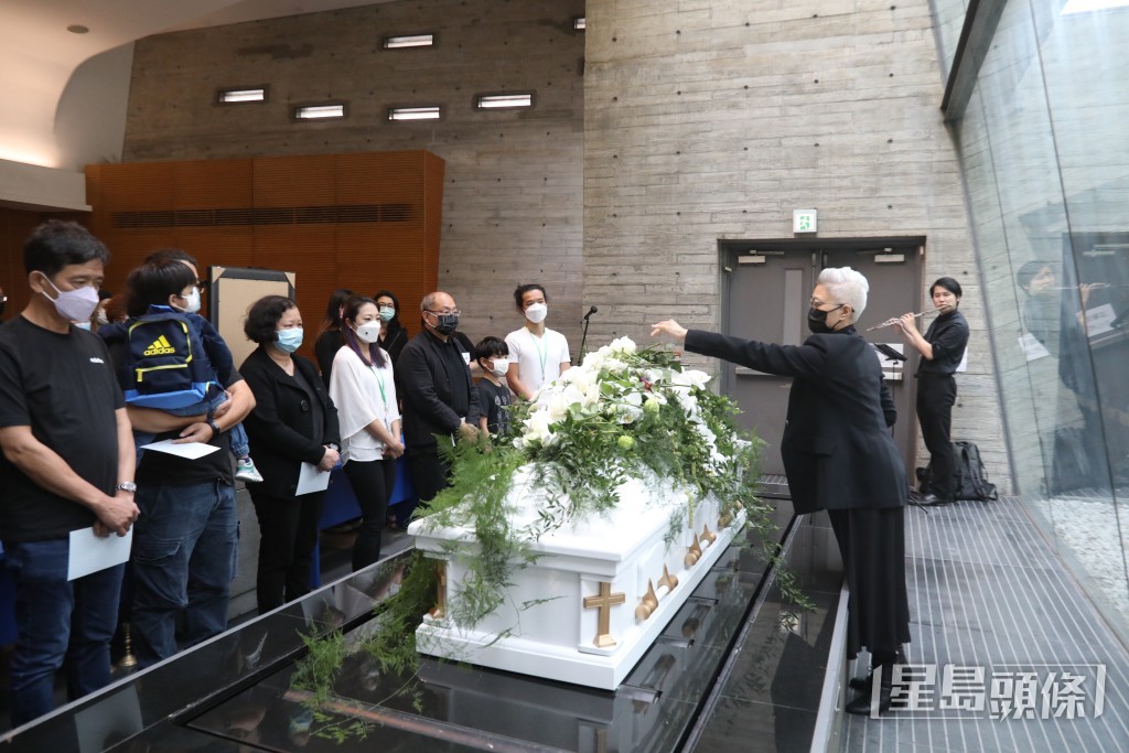 遺孀陳敏兒向丈夫廖啟智的靈柩獻花。