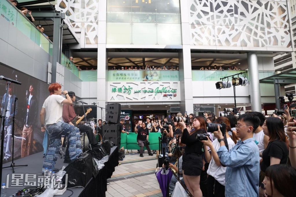 廣場靠近港鐵站出口,人流甚多,不少途人被歌聲吸引駐足觀看。