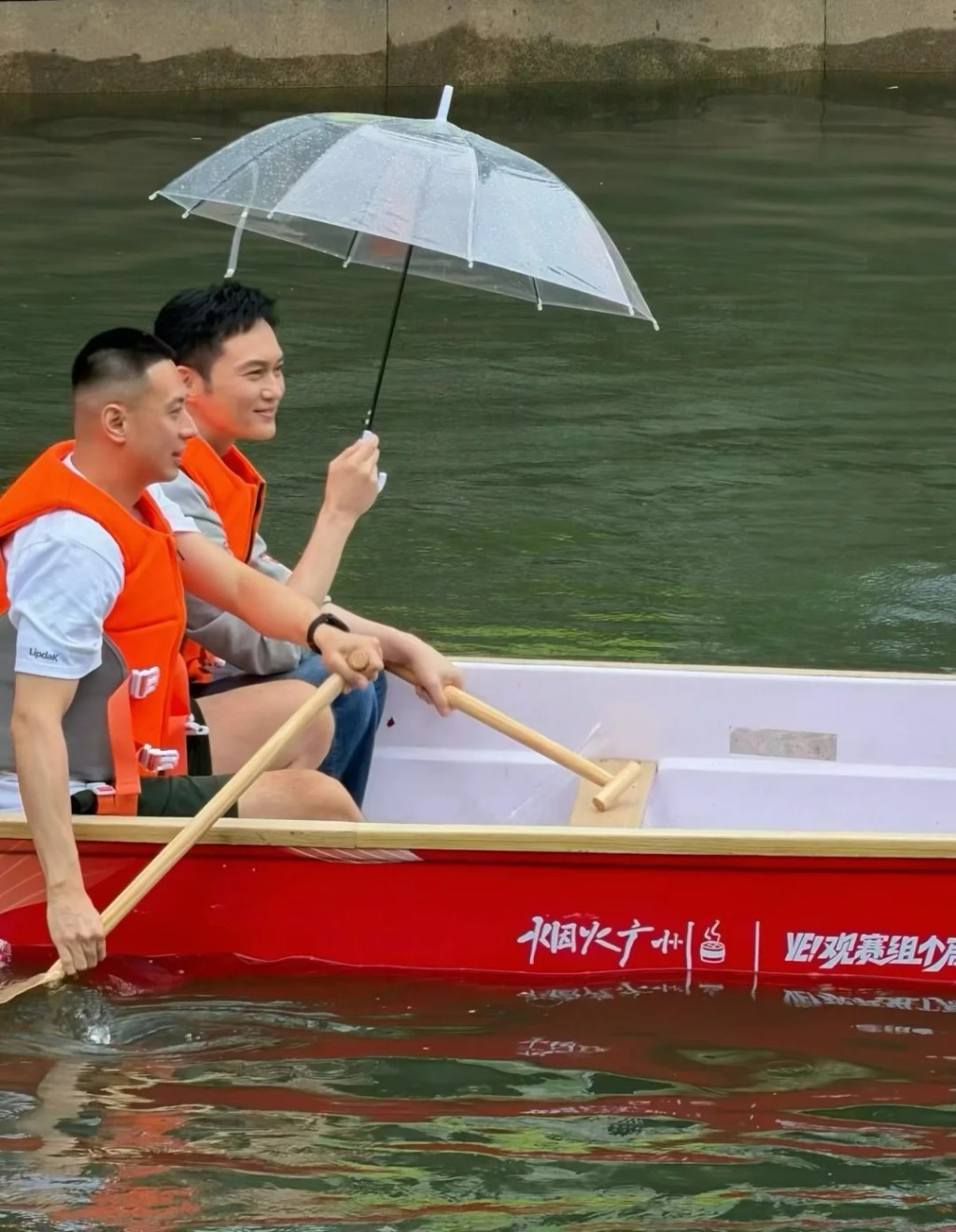 扒龍舟期間下起大雨，張智霖仍撐傘繼續完成活動。