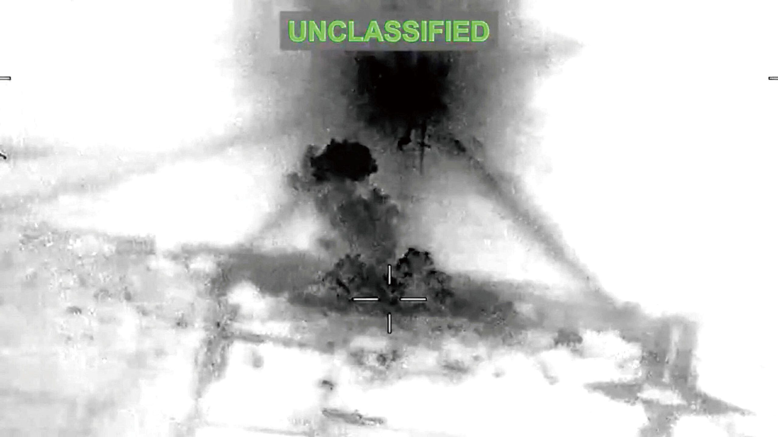 美軍對伊朗發動空襲後,視頻截圖顯示某處不明地點因爆炸而升起濃煙。路透社