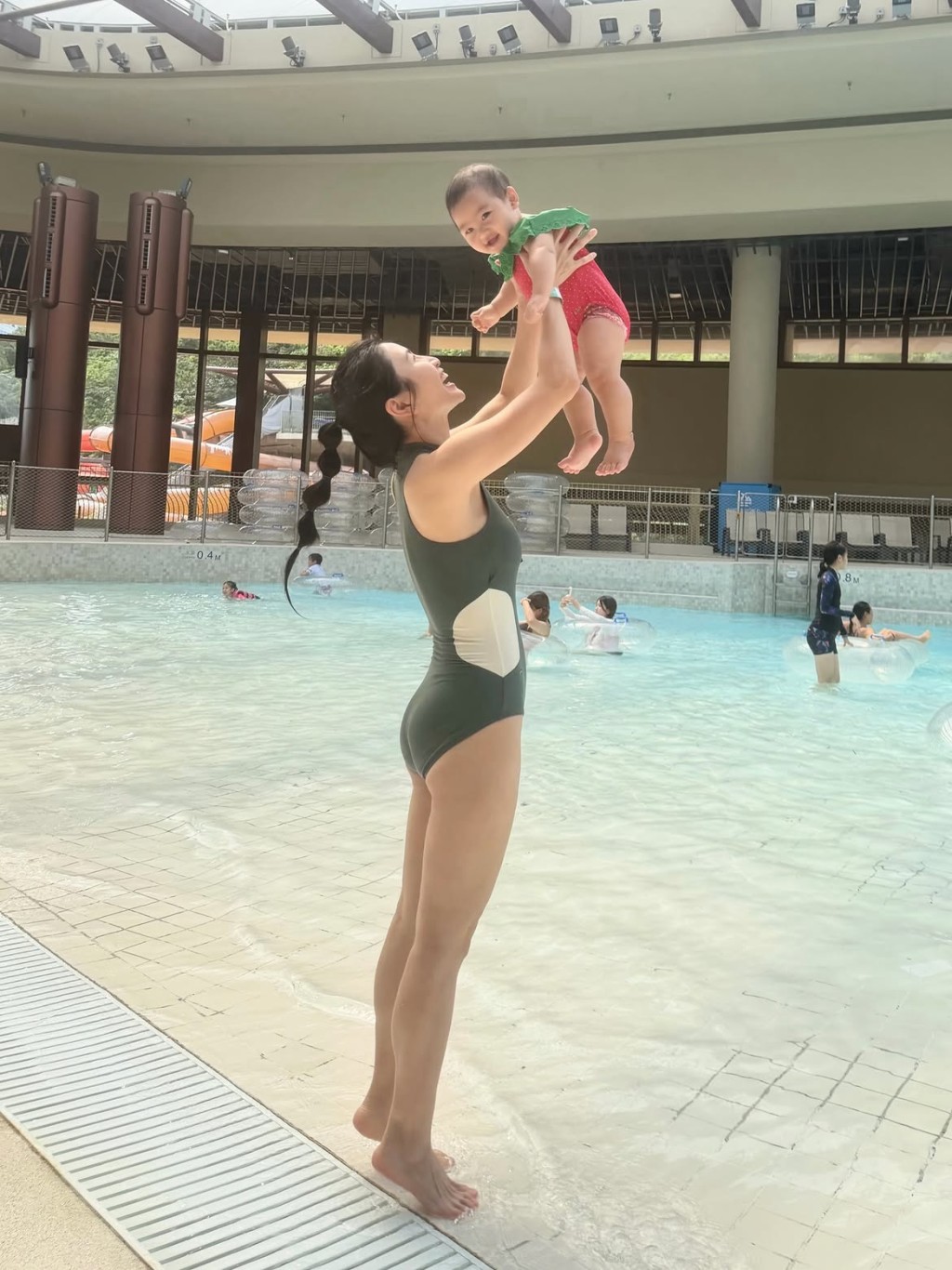 Coffee林芊妤高高舉起女兒，母女二人笑容一致，畫面溫馨。