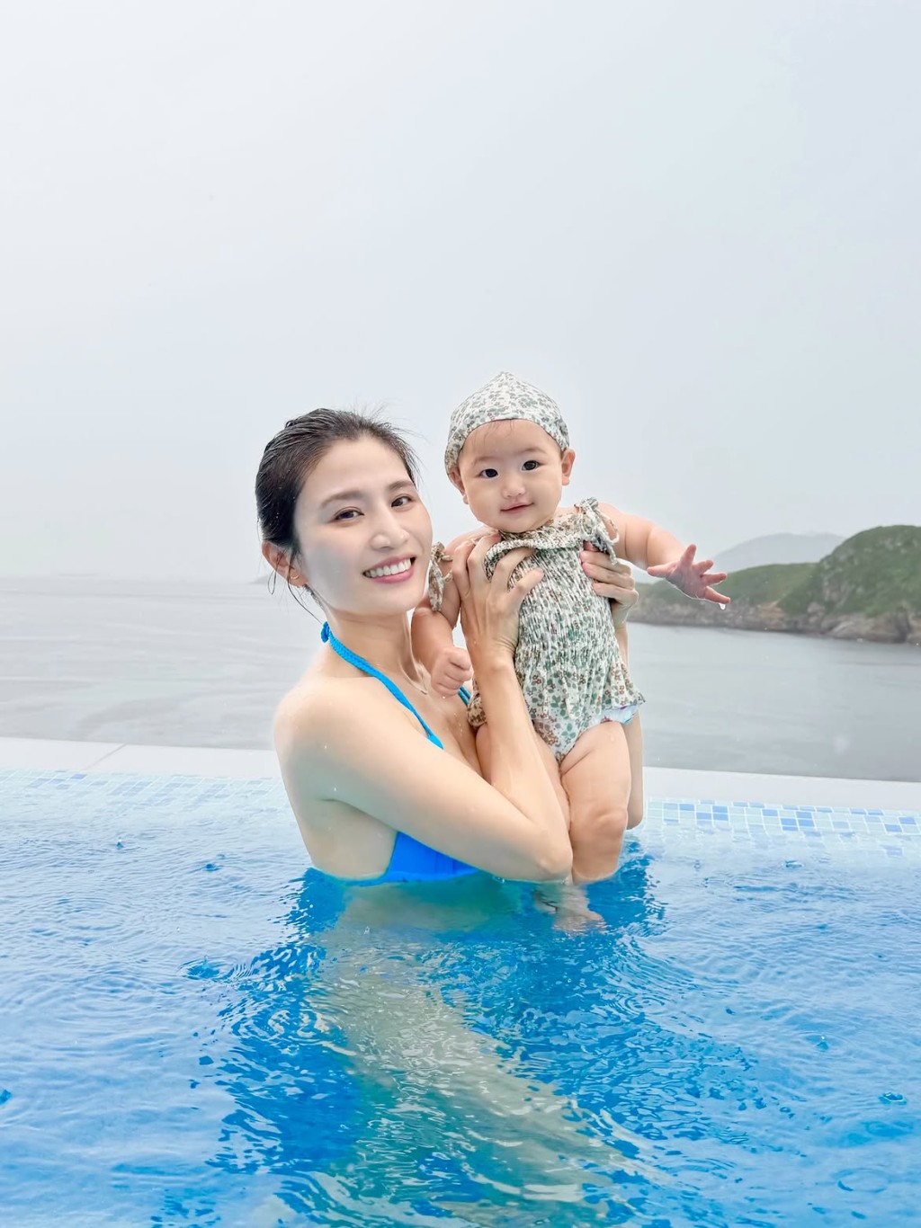 Coffee林芊妤穿上藍色比堅尼，在水中緊抱女兒。