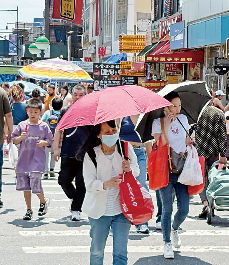 超級熱浪襲擊，皇后區商業核心區法拉盛，汽車排出廢氣，烈日當空，氣溫超過百度華氏， 雨傘的另類用途，擋太陽和降溫，隨處可見。