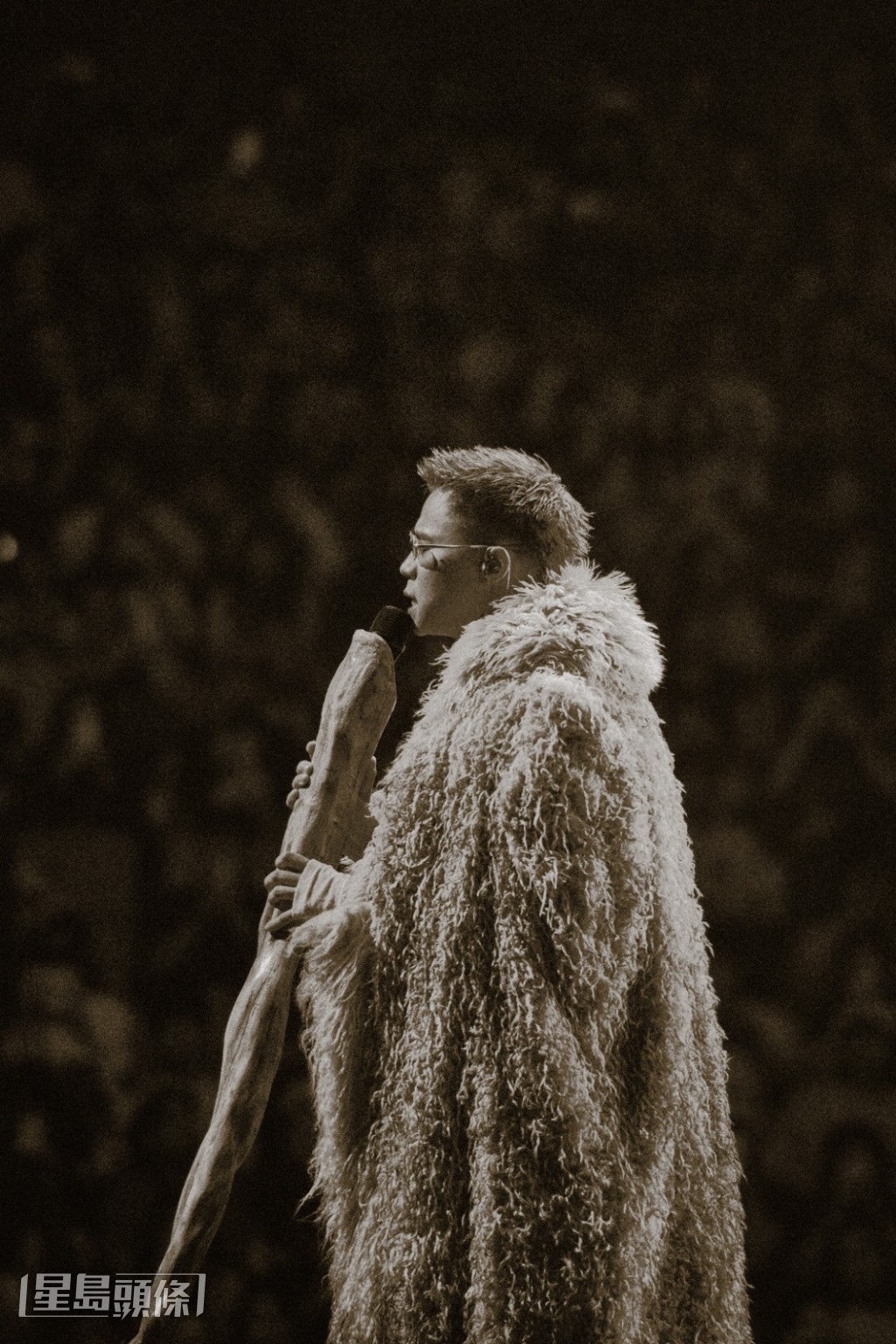 他手執木杖造型的麥克風,在昏黃燈光下接連獻唱數首歌曲。