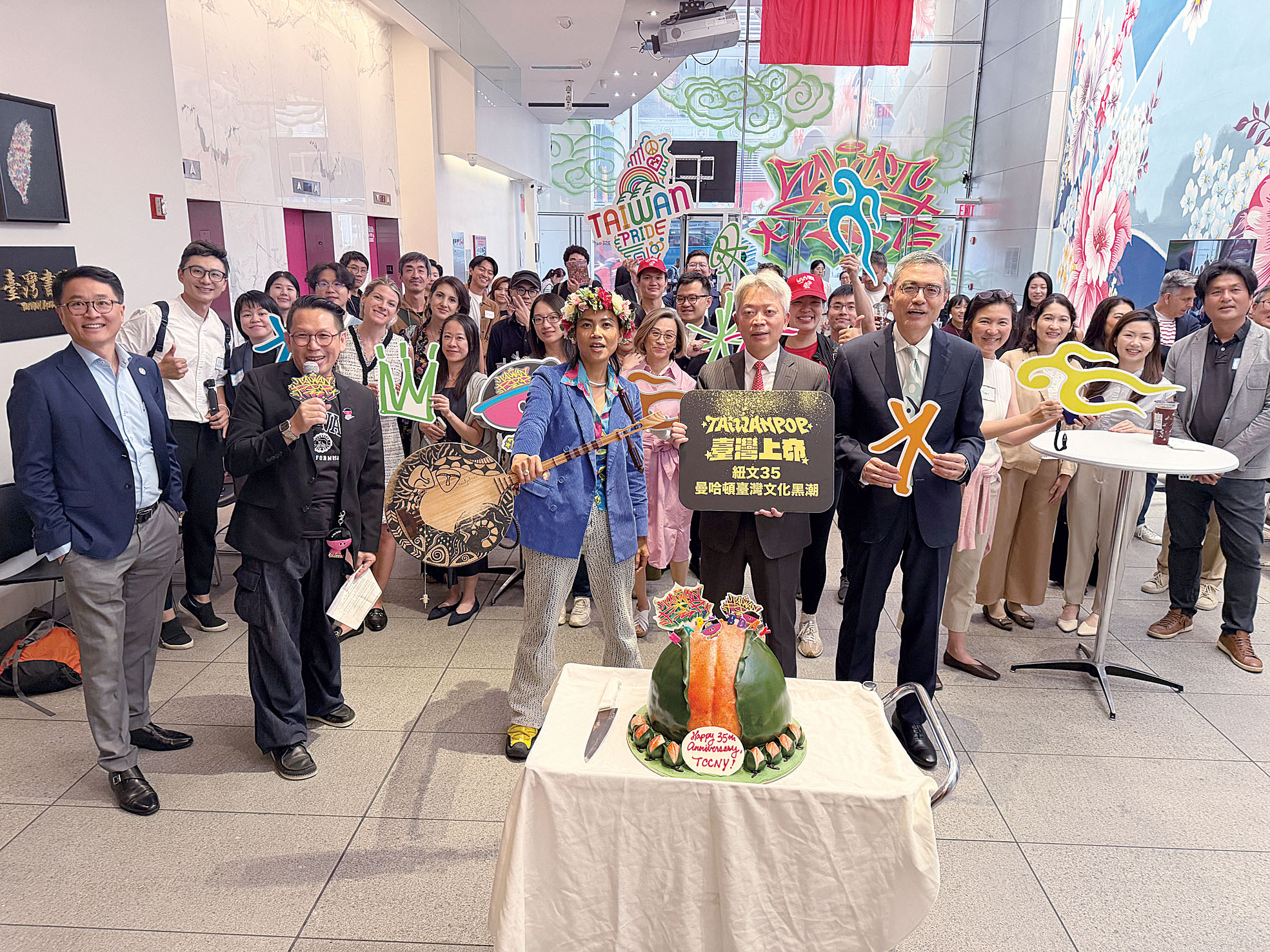 文化中心職員及支持者在巨大壽桃造型蛋糕前合照。