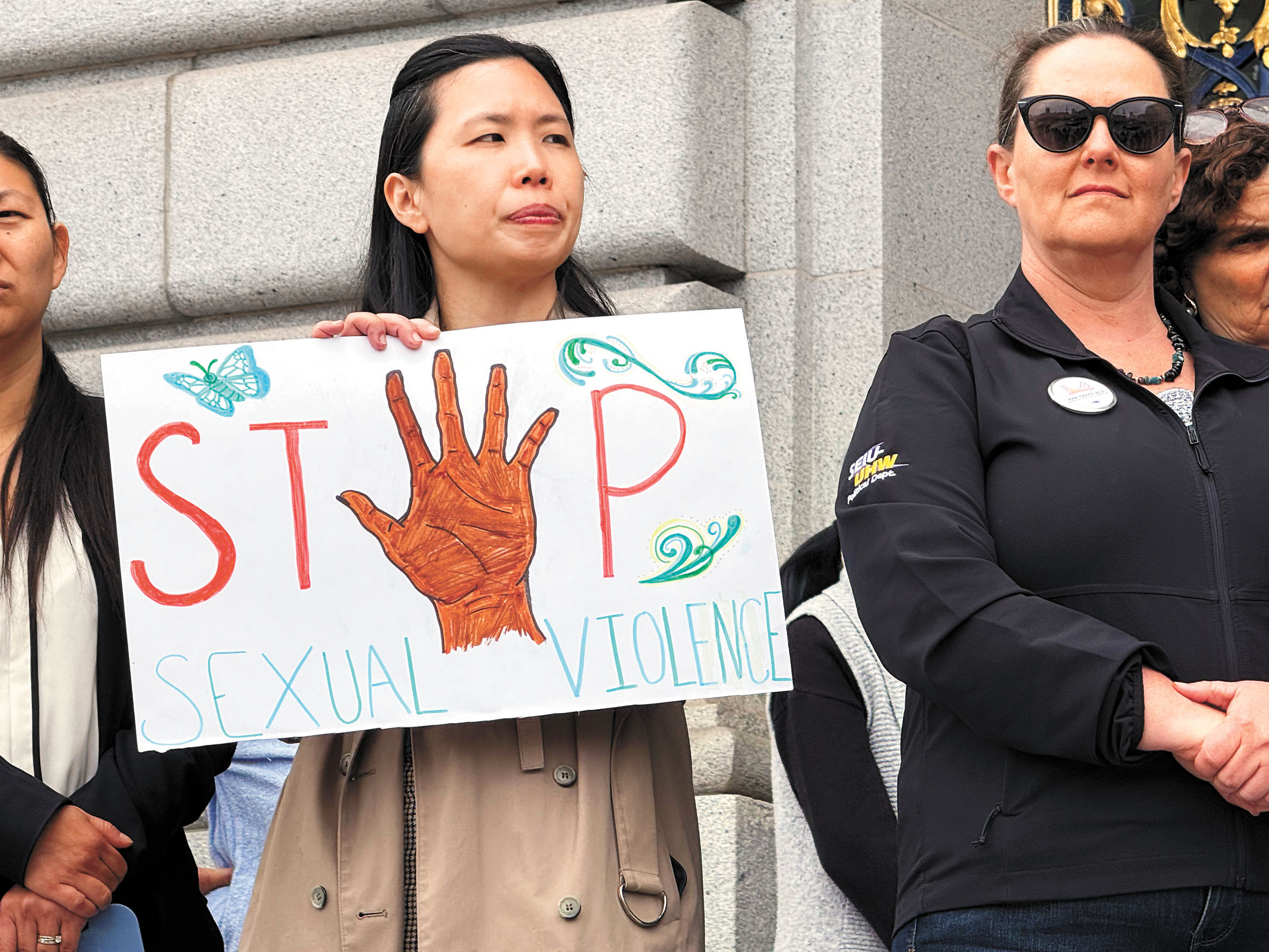中華文化中心(CCC)行政總監梁凱欣手持「Stop Sexual Violence(停止性暴力)」標語聲援性暴力倖存者。 記者陳程威攝