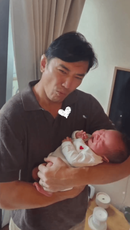 黃長興抱著BB的模樣,笑容十分甜蜜。