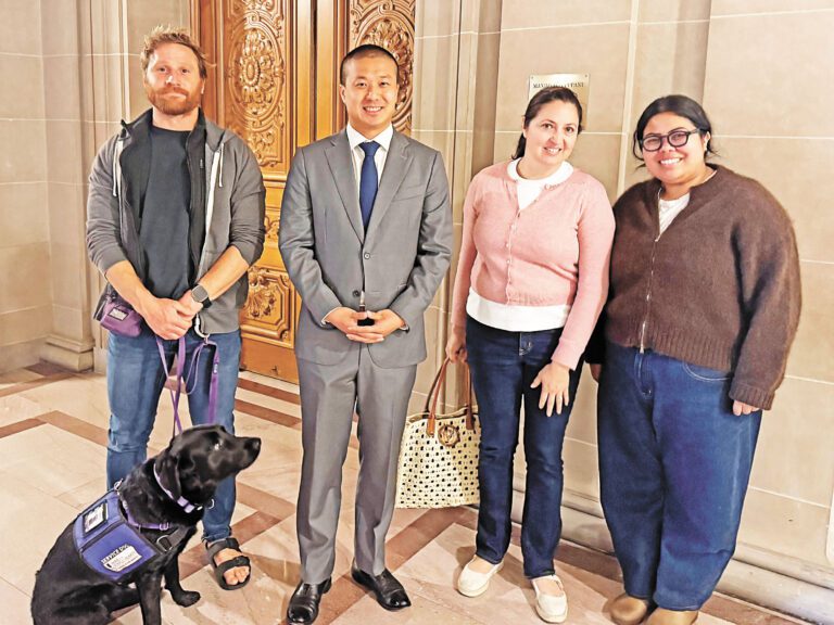 市參事王兆倫與支持法案的社區代表及服務犬於市政廳合影。法案獲市參事會公共安全及社區服務委員會一致通過，將送交市參事會全體審議。市參事辦公室提供