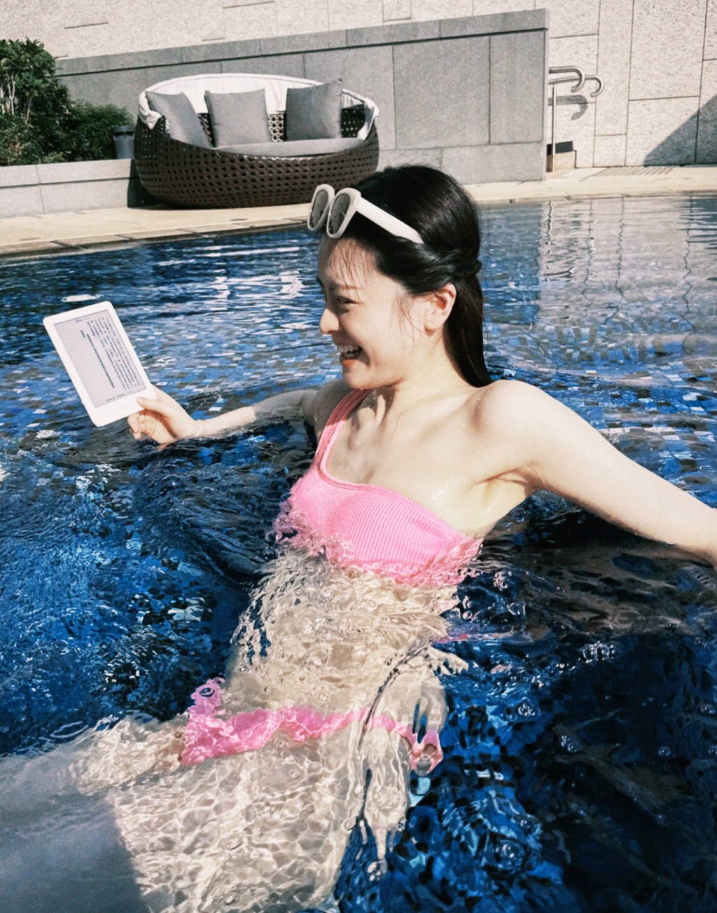 浸在池水中悠閒閱讀電子書的史穎喬,同時展現白滑肌膚。
