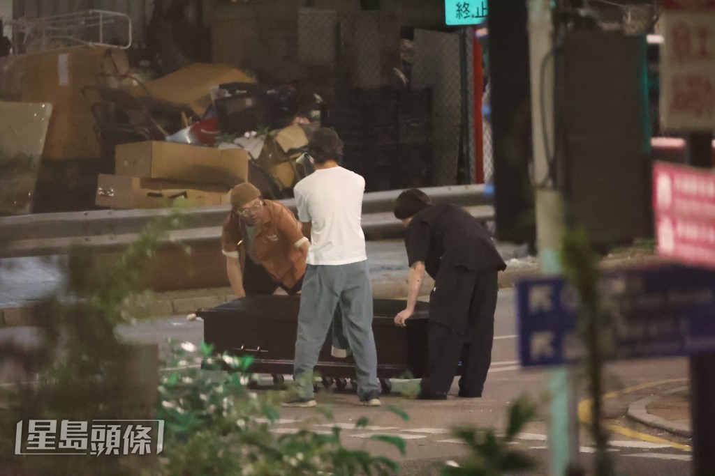 三人於街頭推棺材的畫面,充滿黑色幽默感。