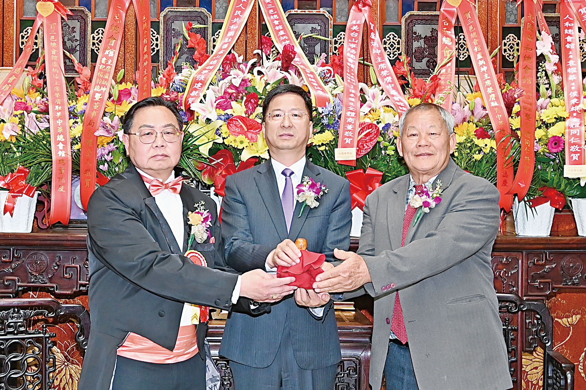 中領館總領事張建敏(中)主持監交,新任總董盧炳坤(左)從滿任總董朱明沾(右)手中接過印信,履新上任。馬紅兵攝