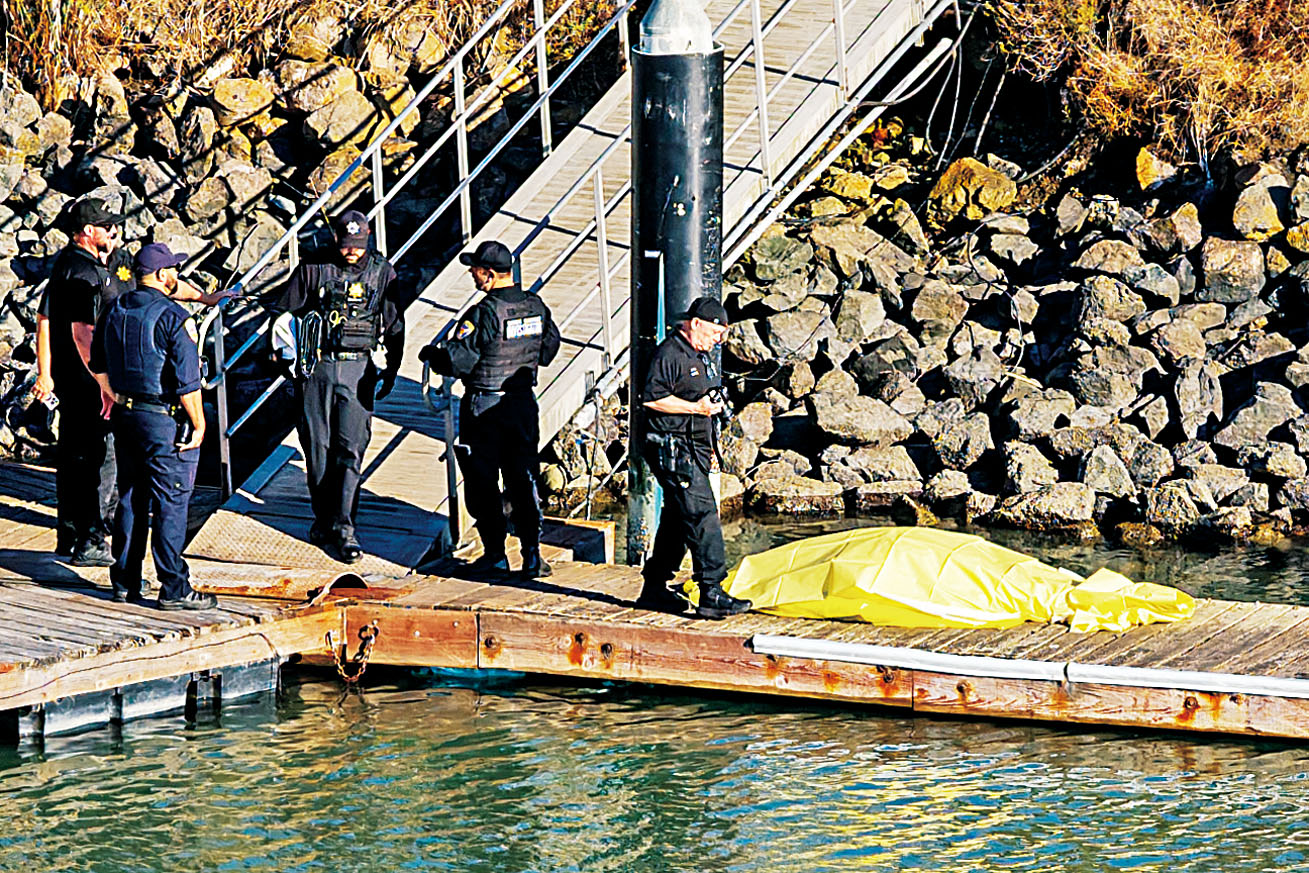 翻船意外中已知有一人死亡(黃膠布蓋著)。美聯社