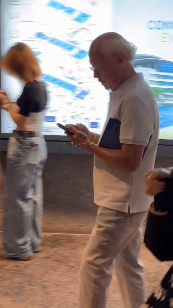 他邊行路邊查看手機。