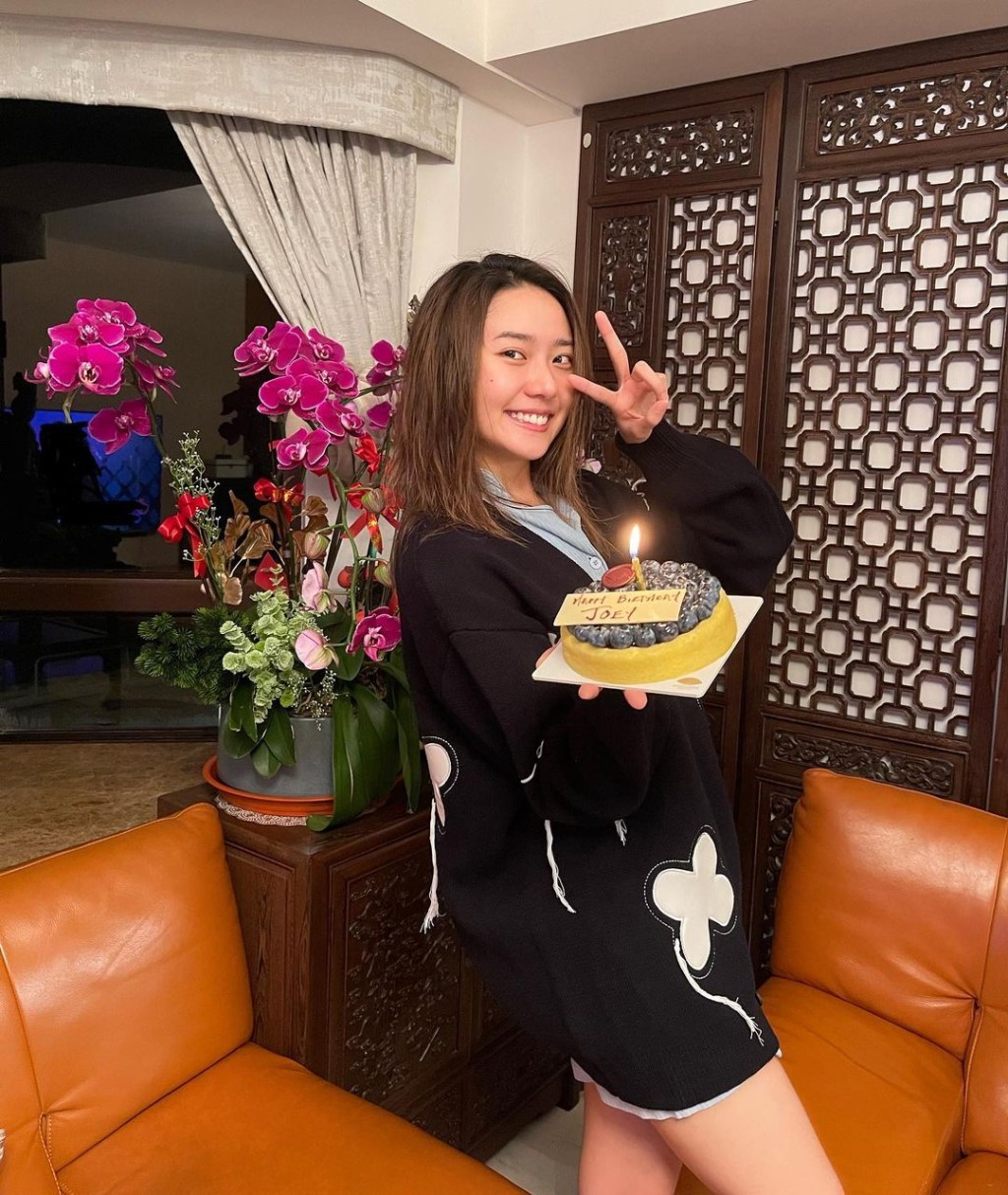客廳採用中式設計,橙色皮梳化後是古典屏風,酸枝櫃上以鮮花點綴,後方是落地大玻璃。