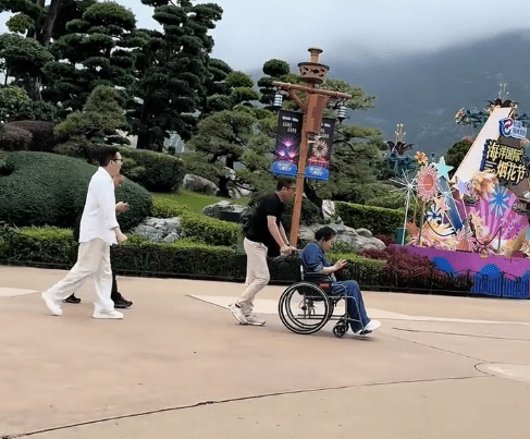 向太坐輪椅出現,向華強緊跟在後。