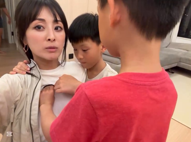 張名雅衣服胸前的開口被大仔伸手遮擋。