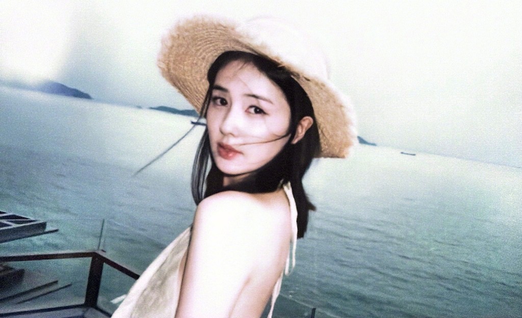 白鹿頭戴草帽回眸，海風吹拂下畫面充滿美感。