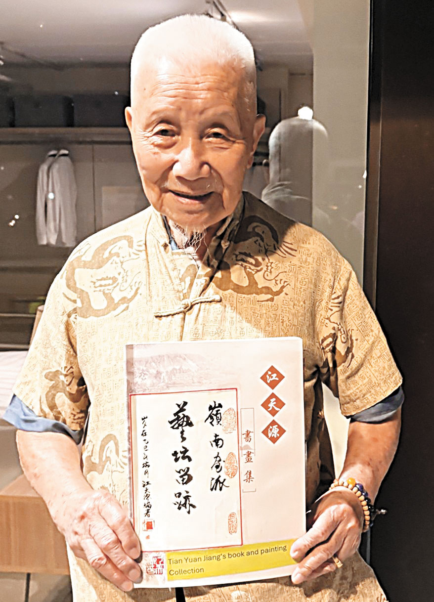 江天源手持《江天源書畫集》第二卷留影。