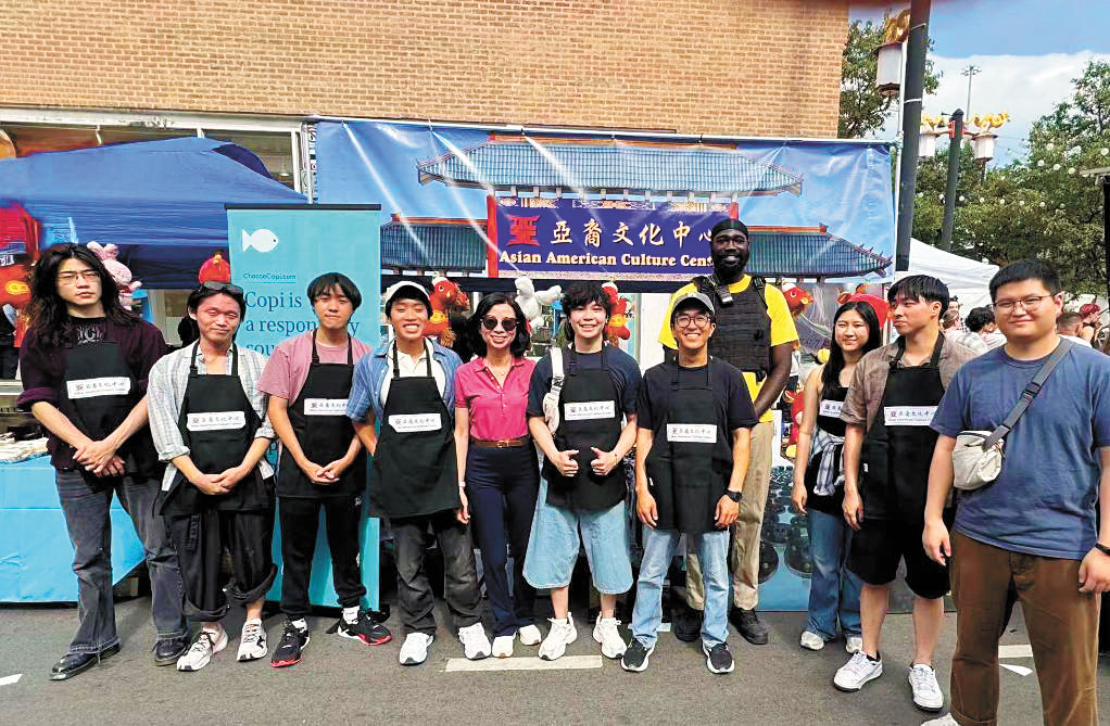 亞裔文化中心今年出動俊男美女當志工,吸引了無數的遊客停步詢問其服務的項目。 梁敏育攝