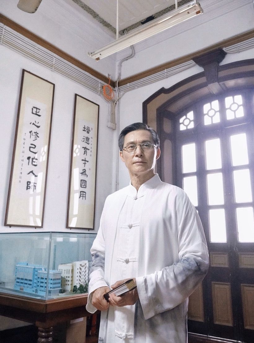 他一身樸素長褂配上細框眼鏡,手持折扇,專注研究學問。