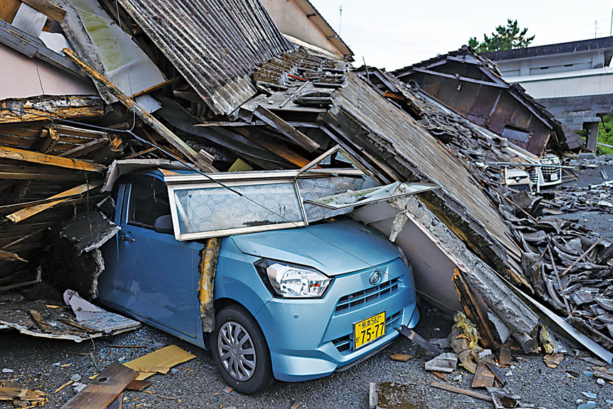 一輛汽車被倒塌建築的廢墟壓毀。路透社