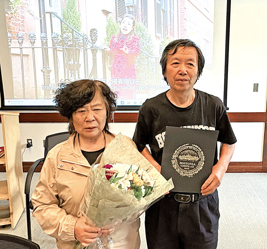 潘潔父母手持鮮花和市議會緬懷潘潔的決議案合影。