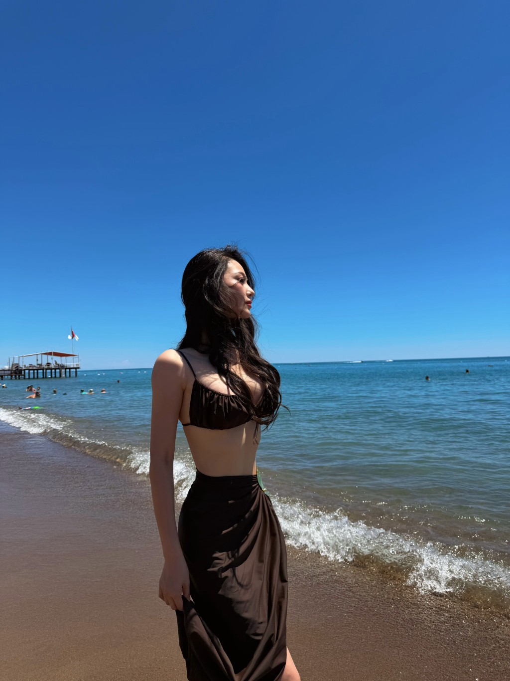 在陽光與海灘的襯托下,她盡情伸展,展現出完美的S形曲線。