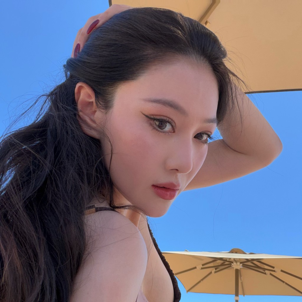 張馨予輕撥秀髮,眼神流露迷人魅力。