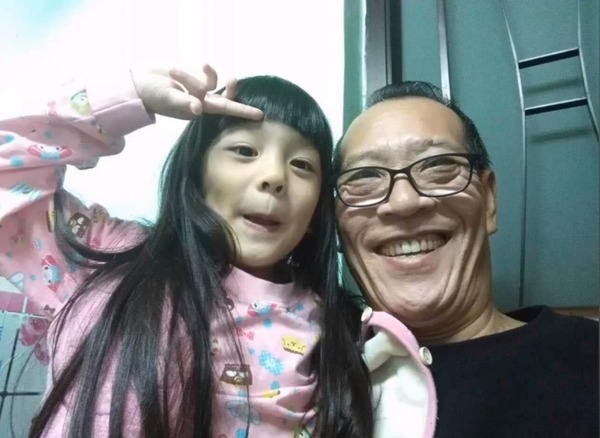 戲裡常演惡人的鍾發,私下是慈祥祖父,抱著孫女笑開懷。