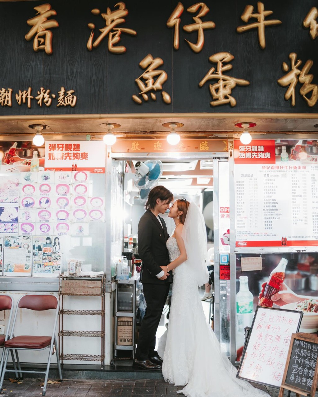 李亦喬與未婚夫阿招在粉麵店門外的大招牌前合照留念。