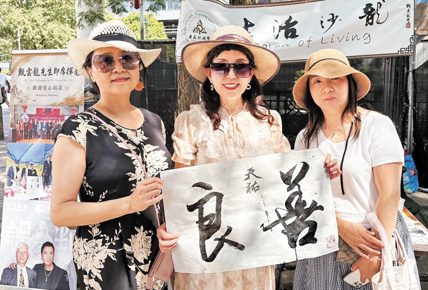 (左起)郭凌、王仲麗及一位遊客同甄雲龍的墨寶合影。 李強攝