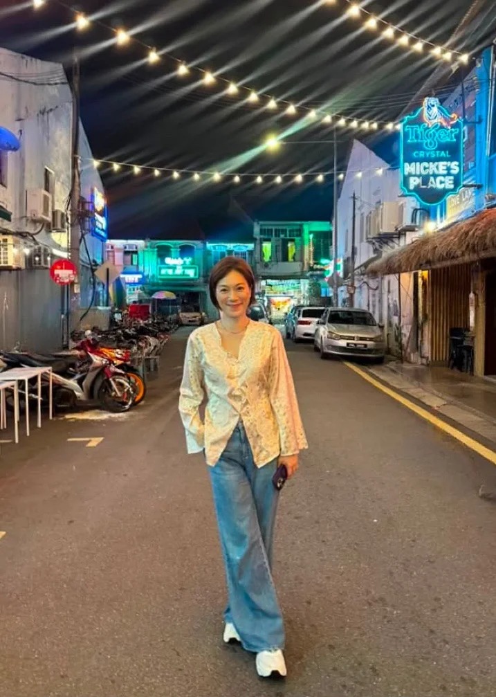 夜遊檳城街頭,燈光下的張可頤展露燦爛笑容。