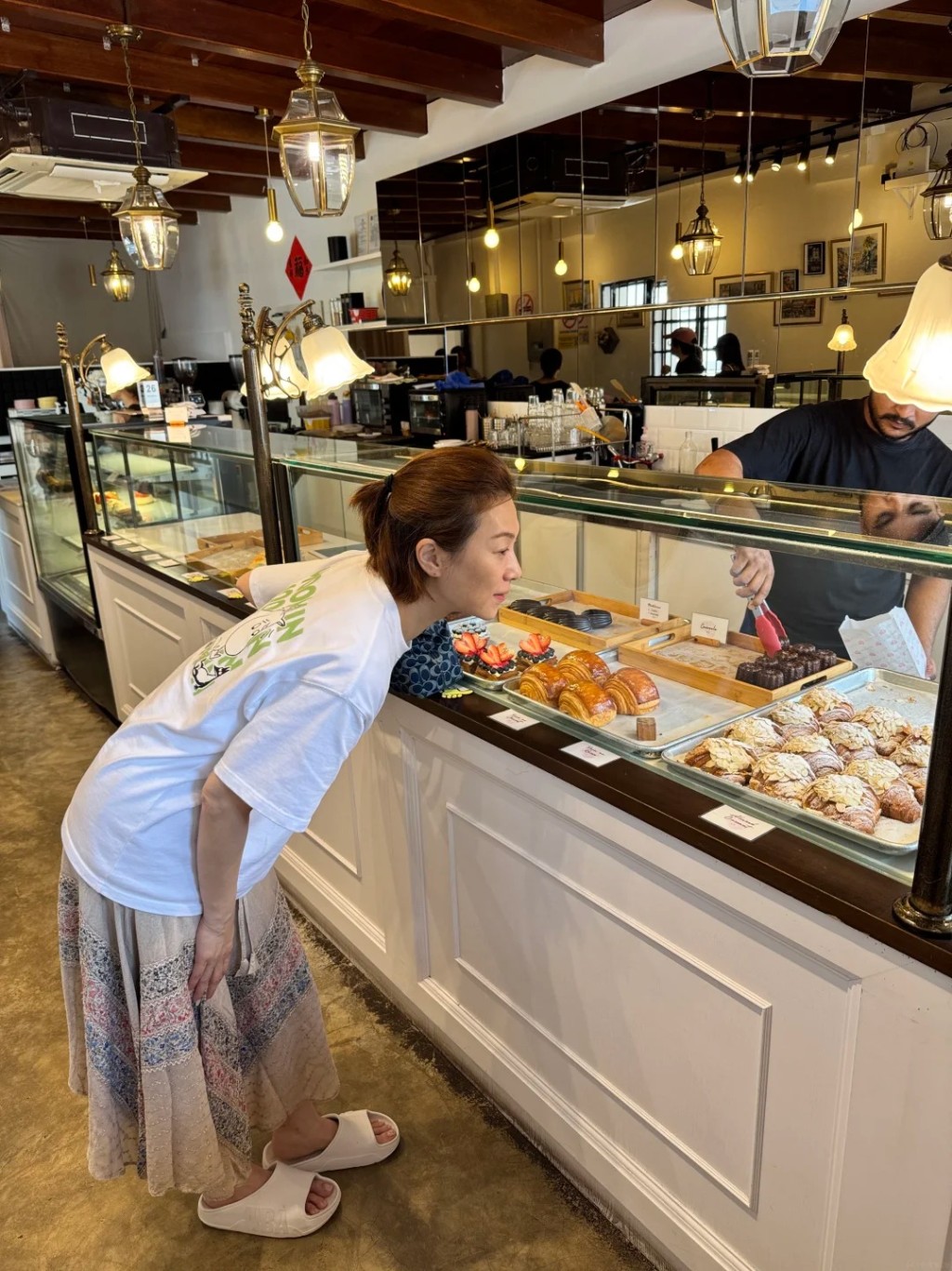 在檳城麵包店內,張可頤專注挑選甜品,其纖瘦手臂與手背青筋引起注意。