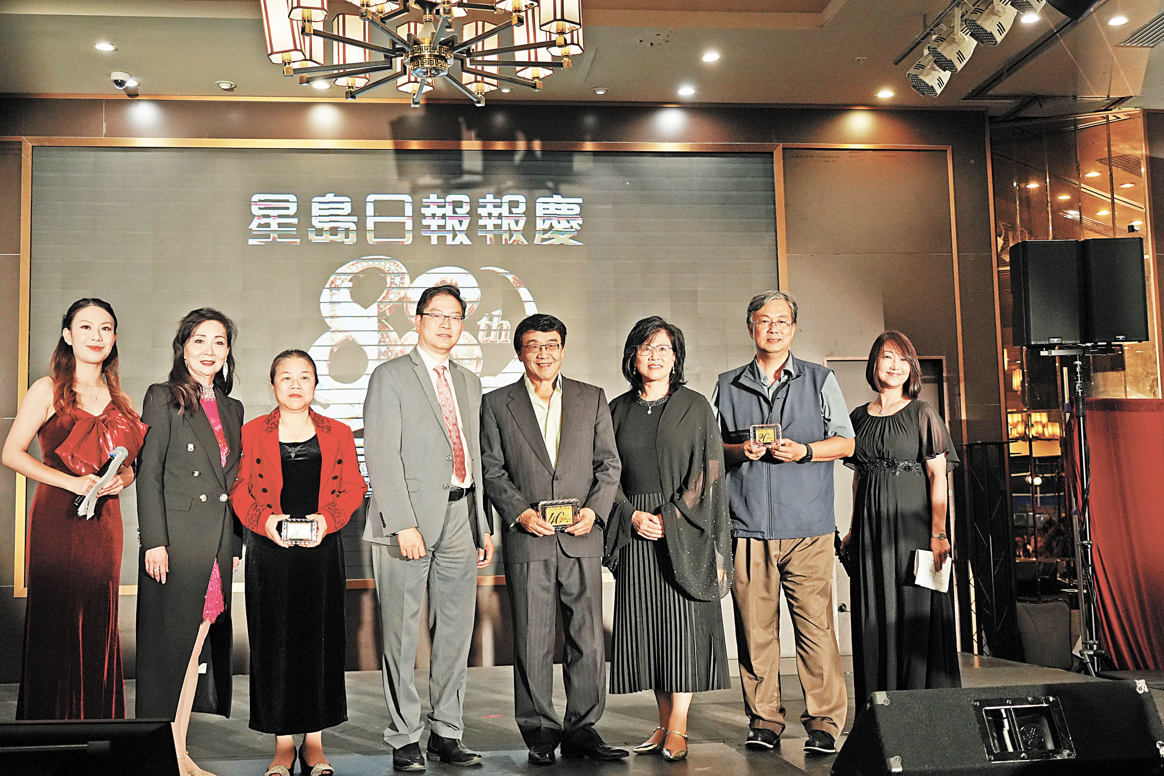星島表揚多年來並肩同行的資深員工龔浩海（右四）、黃偉江（右二）和古玉英（左三）。本報記者攝